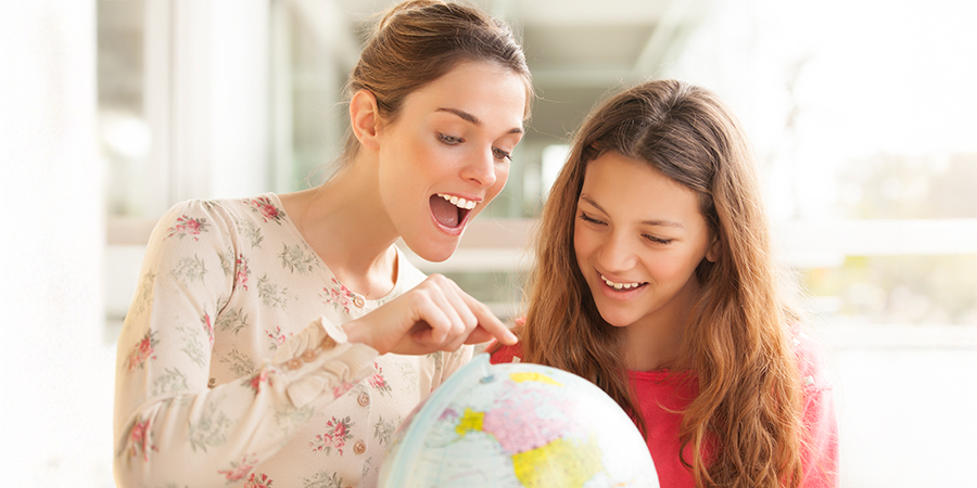 professora e aluna vendo o globo terrestre