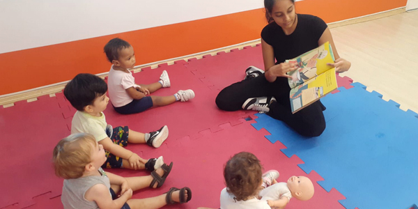 Crianças sentadas com a professora no estilo brincar e aprender do Colégio Villa-Lobos. 