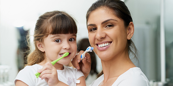 filha e mãe escovando dente